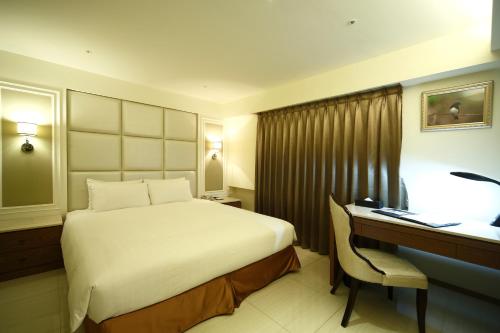 高雄鸟巢顶级商旅的酒店客房配有一张床和一张带电脑的书桌