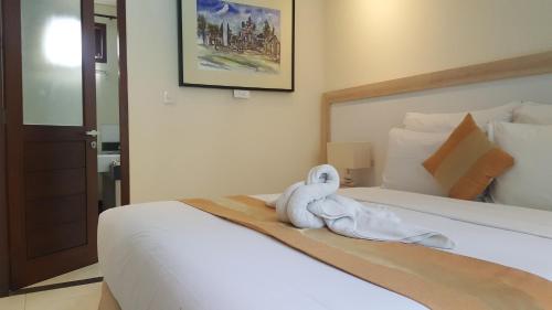 沙努尔亚曼旅馆的一间酒店客房,配有一张带毛巾的床