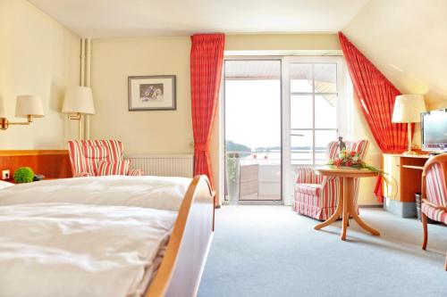 Bosau施特劳尔斯湖滨酒店的酒店客房设有一张床和一个阳台。