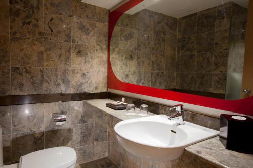 雅加达Hotel KIMAYA Slipi Jakarta By HARRIS的一间带水槽、卫生间和镜子的浴室