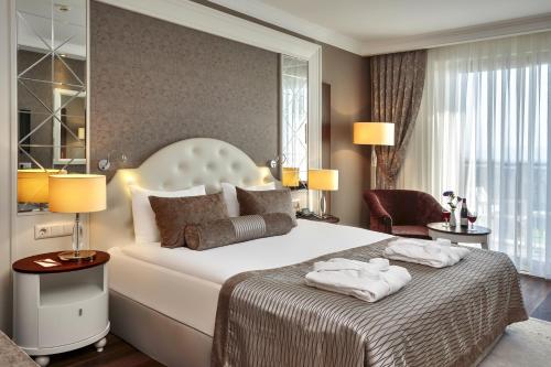 奥兹德雷Sunis Efes Royal Palace Resort & Spa的一间卧室配有一张大床和两条毛巾