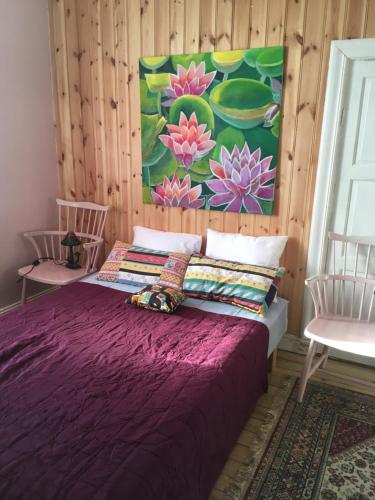 KrylboParkgatan villa的一间卧室配有一张紫色的床和两把椅子
