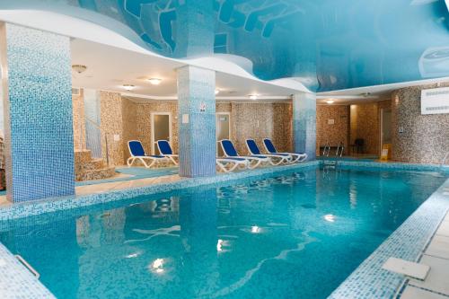 特鲁斯卡韦茨斯维迪亚兹度假酒店的水中蓝色椅子的酒店客房的游泳池