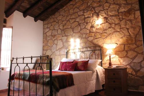 Puebla de San MiguelCasa Rural Majico的一间卧室设有一张床和石墙