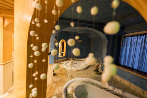 利维尼奥塞沃酒店的浴室设有2个水槽、浴缸和镜子