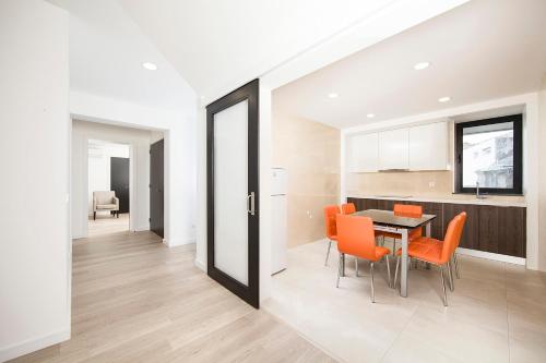 马达莱纳XA Apartments RRAL-579的厨房以及带橙色椅子和桌子的用餐室