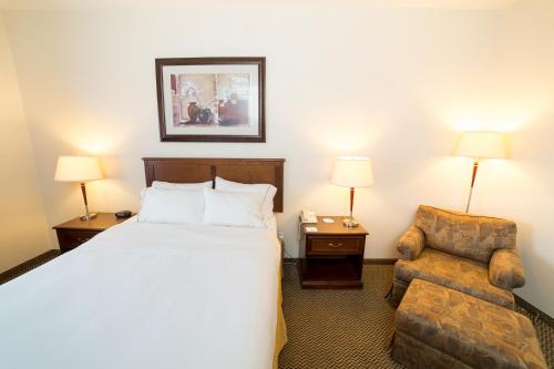 Drayton Valley德雷顿瓦利智选假日酒店的配有一张床和一把椅子的酒店客房