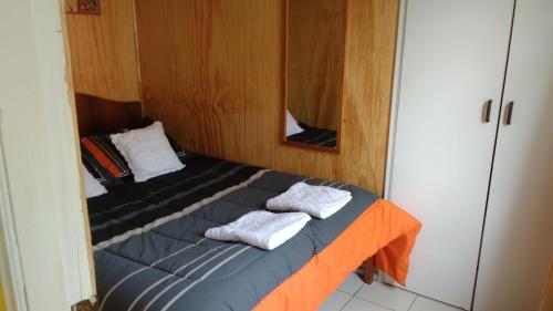 奥索尔诺Cabaña Don Claudio的一张小床,房间里备有毛巾