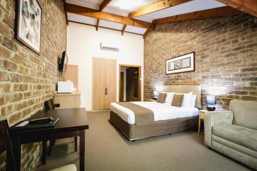 汉道夫The Lodge的一间卧室设有一张床和砖墙