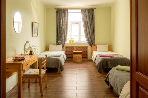 乌兰巴托扎亚旅馆的客房设有两张床、一张桌子和一个窗户。