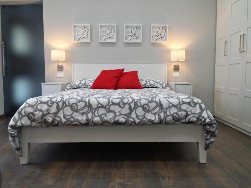 卡尼洛瑞维拉Casa Lucia的一间卧室配有一张带两个红色枕头的床