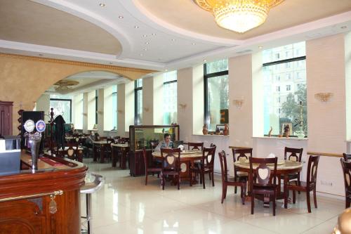 敖德萨山海蓝调酒店的配有桌椅的餐厅,以及坐在桌子上的人