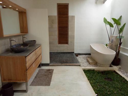 日惹日惹蓝色花园住宿加早餐旅馆的浴室配有盥洗盆、浴缸和盥洗盆