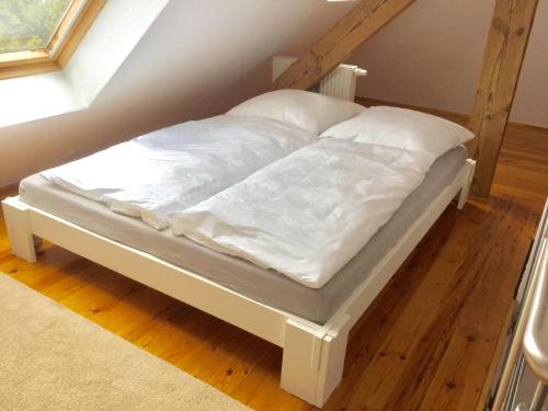 罗斯托克Ferienwohnung Rostock的一张带白色床单和枕头的床