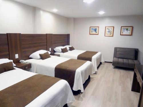 昆卡Hotel Patrimonio的酒店客房,配有两张床和椅子