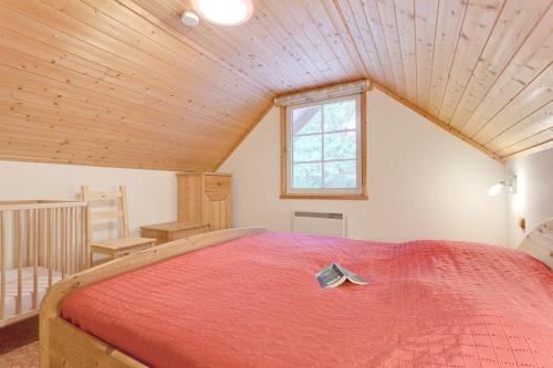 乌塞林Haus-am-See的一间卧室配有一张带红色毯子的大床