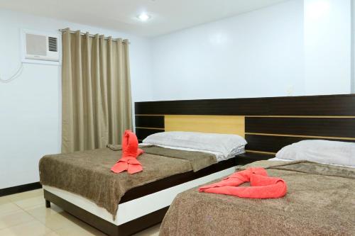 宿务环球88特乐宾馆的两张位于酒店客房的床,配有毛巾