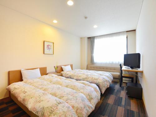 羽咋市能登路康乐饭店的酒店客房设有两张床和电视。