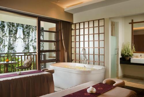 乌布乌布乡村酒店的一间带大浴缸的浴室和一个阳台