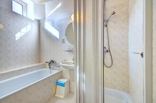 大洛西尼Hotel Pizzeria Istria的带浴缸、盥洗盆和卫生间的浴室