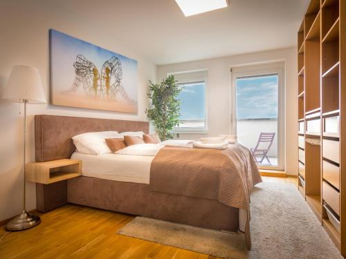 维也纳天空9号顶楼公寓的一间卧室设有一张大床和一个窗户。