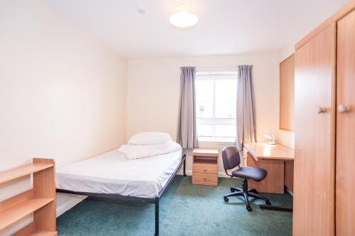 爱丁堡爱丁堡大厅欧元旅馆的一间卧室配有一张床、一张桌子和一把椅子