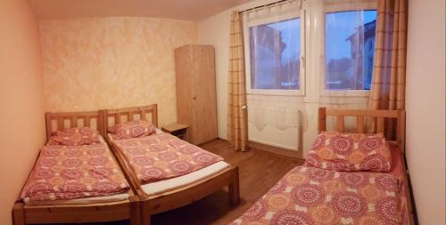 弗林布尔克Apartmány Mimpi的小房间设有两张床和窗户