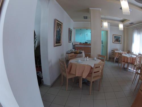 卡斯托里亚Hotel Orestion的一间带桌椅的用餐室和一间厨房