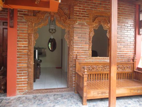 日惹鲁玛优齐旅馆的砖砌建筑的入口,木凳