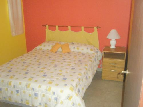 拉斯格路塔斯Sendero Patagonico的一间卧室配有一张橙色墙壁的床