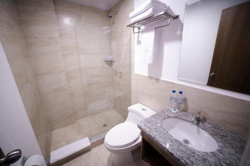曼塔Aquamarina Hotel的浴室配有卫生间、盥洗盆和淋浴。