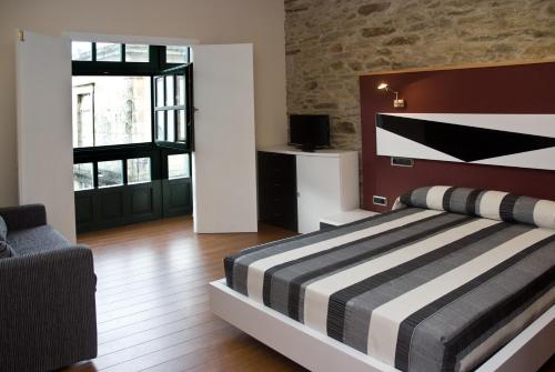 圣地亚哥－德孔波斯特拉多莫斯斯特拉公寓式酒店的一间卧室配有一张带黑白条纹毯子的床