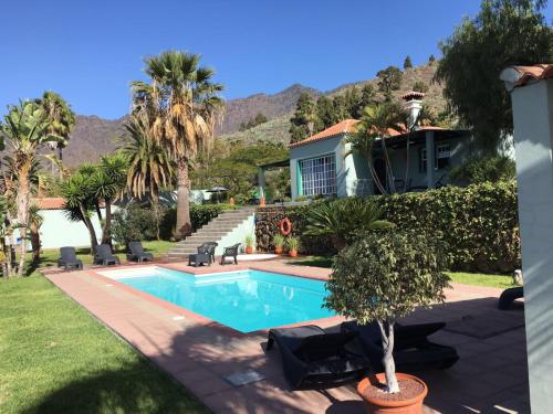 洛斯·亚诺斯·德·阿里丹La Camuesa-Adults Only的一座带游泳池和棕榈树的房子