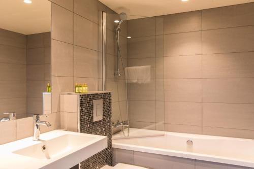 苏特兰Thon Partner Hotel Sortland的浴室配有2个盥洗盆和1个浴缸。