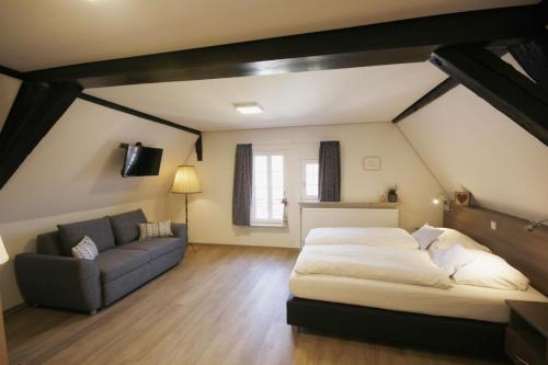 巴特温普芬Gästehaus zur Sonne的一间卧室配有一张大床和一张沙发