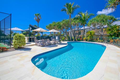 日出海滩海滩客度假酒店的棕榈树度假村内的游泳池