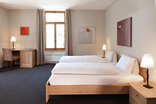 Guttannen翰德克自然度假酒店的酒店客房配有两张床和一张书桌