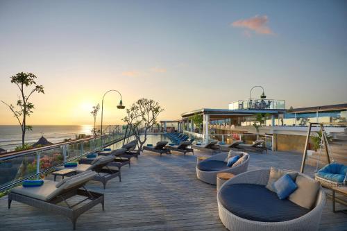 坎古ASTON Canggu Beach Resort的一个带沙发和椅子的甲板和大海