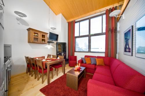 普哈圣山皮亚圣洁假日俱乐部的客厅配有红色的沙发和桌子