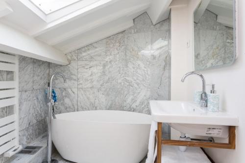 巴黎蒙马特ADM工作室旅馆的浴室配有白色浴缸和水槽