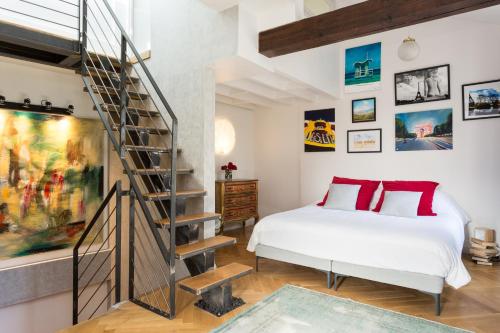 巴黎蒙马特ADM工作室旅馆的一间卧室设有一张床和一个螺旋楼梯