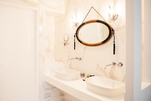 波尔多安尼克司杜邦酒店的白色的浴室设有两个盥洗盆和镜子