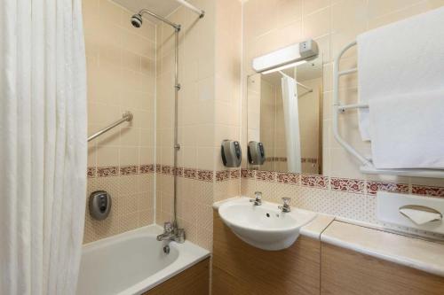 Strensham图克斯伯里戴斯酒店的浴室配有盥洗盆、镜子和浴缸