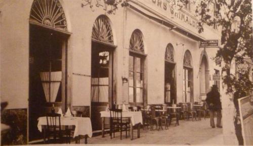 巴斯蒂亚Hôtel Les Voyageurs的一张带桌椅的餐厅的旧照片