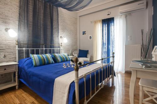 雅典Elegant and Safe Gold and Blue Apartment walk to Acropolis的一间卧室配有一张带蓝色棉被的床