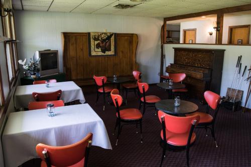 伯利恒The Wayside Inn的一间带桌椅和电视的用餐室