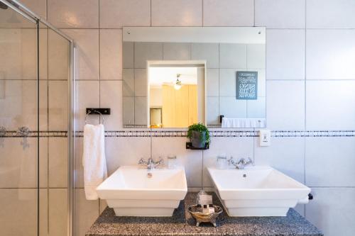 开普敦大西洋海滩别墅酒店的浴室设有2个水槽和镜子