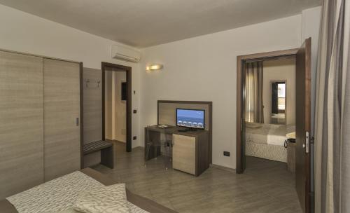 利多迪卡马约雷Hotel Lido Inn的带电视的客厅和卧室