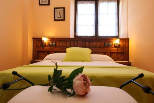 Hoz de Anero托拉亚阿帕特蒙托斯公寓的一间卧室,配有一张桌子上花的床铺