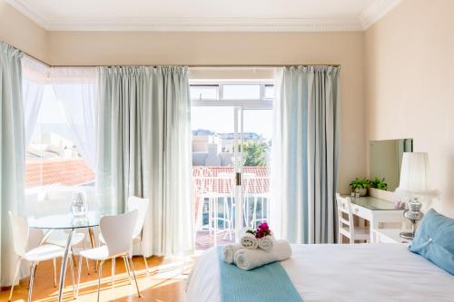 开普敦大西洋海滩别墅酒店的一间卧室配有一张床和一张桌子及椅子